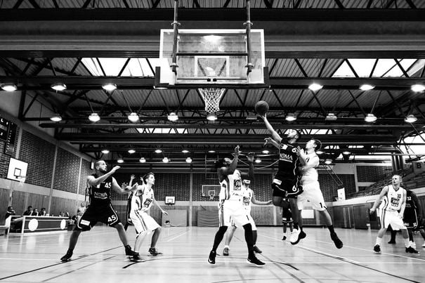 A team playing basketball on the court and had sports injury screenings beforehand.