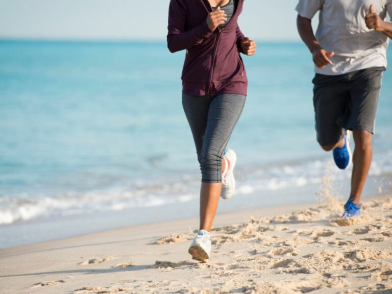 Male and female runners on the beach